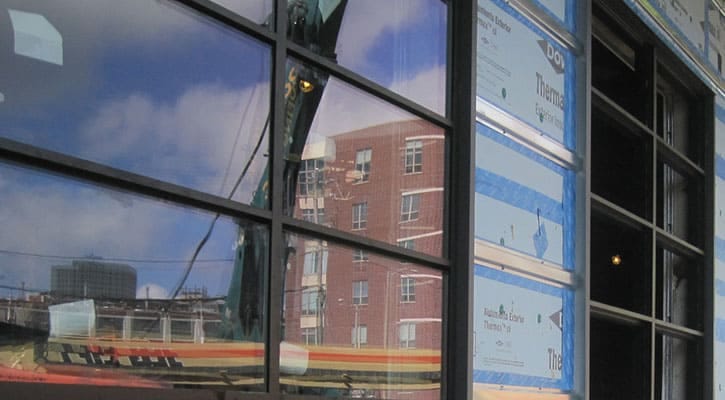 Construction photo of the progress at the adaptive re-use renovation project for the PRA Milwaukee Design Office at 209 S. Water Street, Milwaukee, Wisconsin showing aluminum windows infilling the overhead doors of the prior loading dock