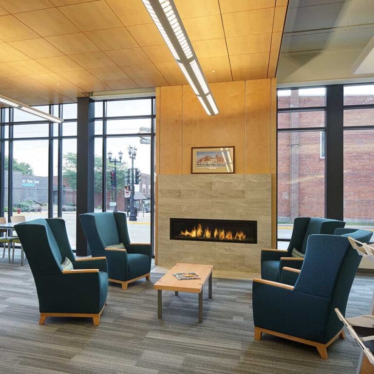 Platteville Public Library Fireplace and Lounge Area. The fireplace features porcelain tile and wood ceiling, creating a focal point and pleasant area to read.